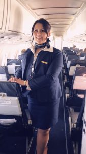 Flight attendant standing inside airplane